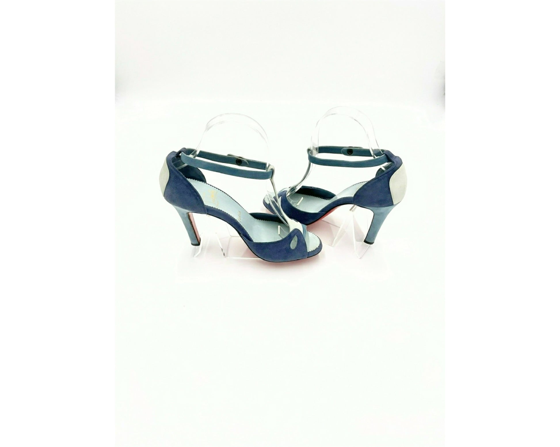 Louboutin high heels, featuring a suede texture and a gradient of light to dark blue, with the brand's distinctive red sole