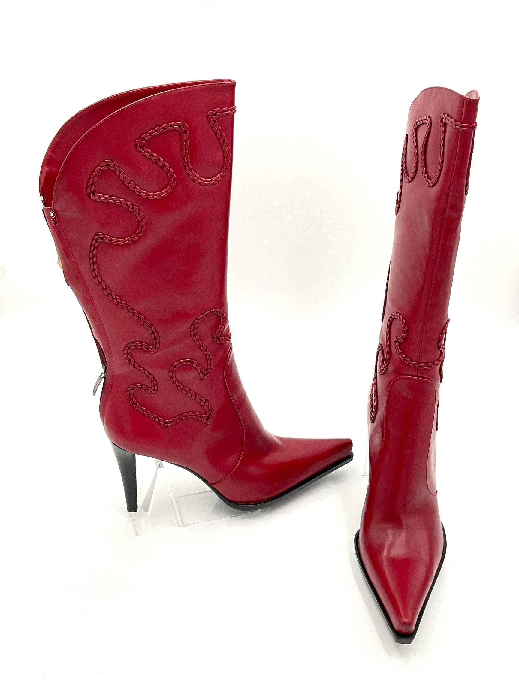 Red cowboy boots with decorative stitching on a white background