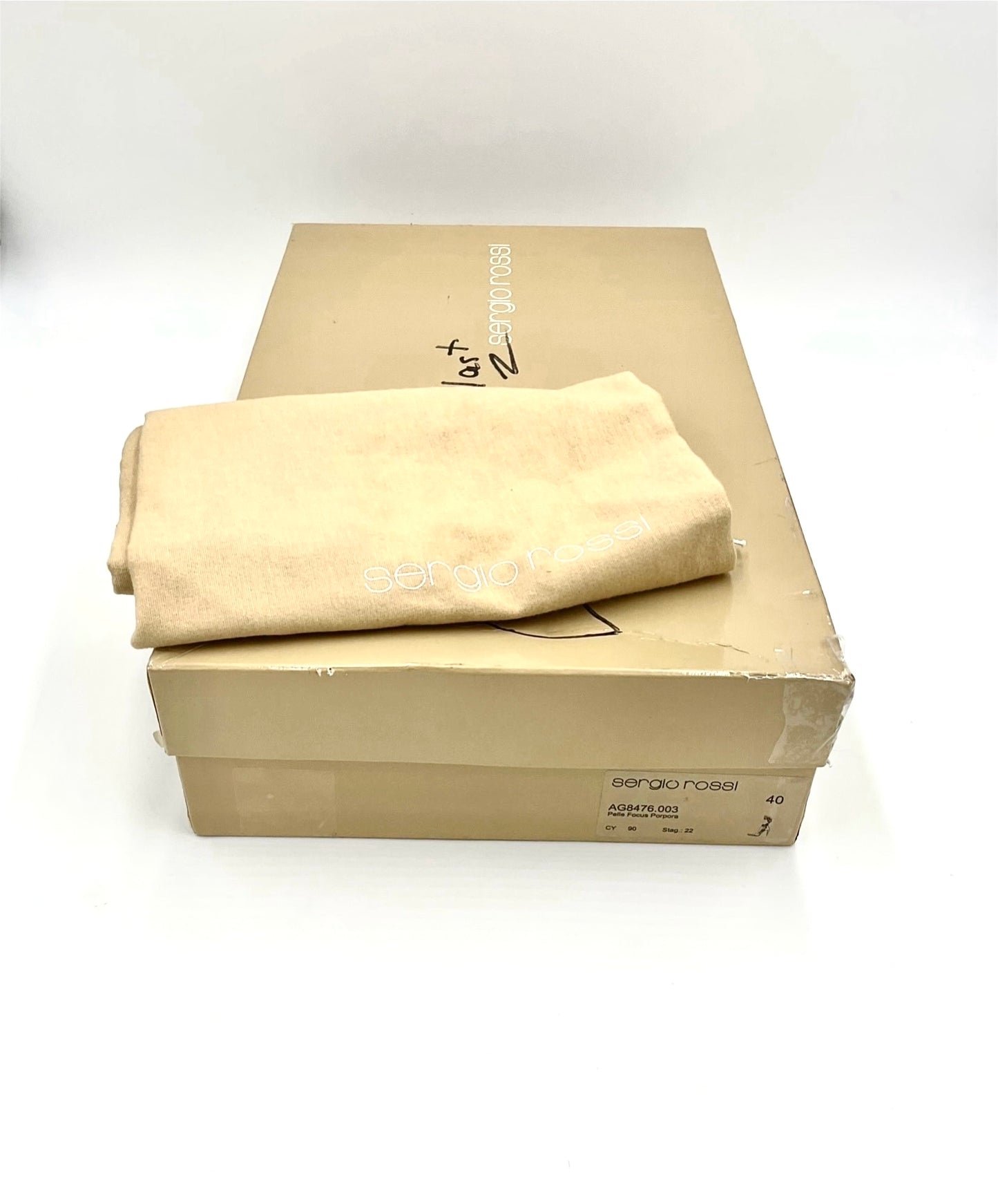 Beige original shoebox with a folded beige dust cover on a white background