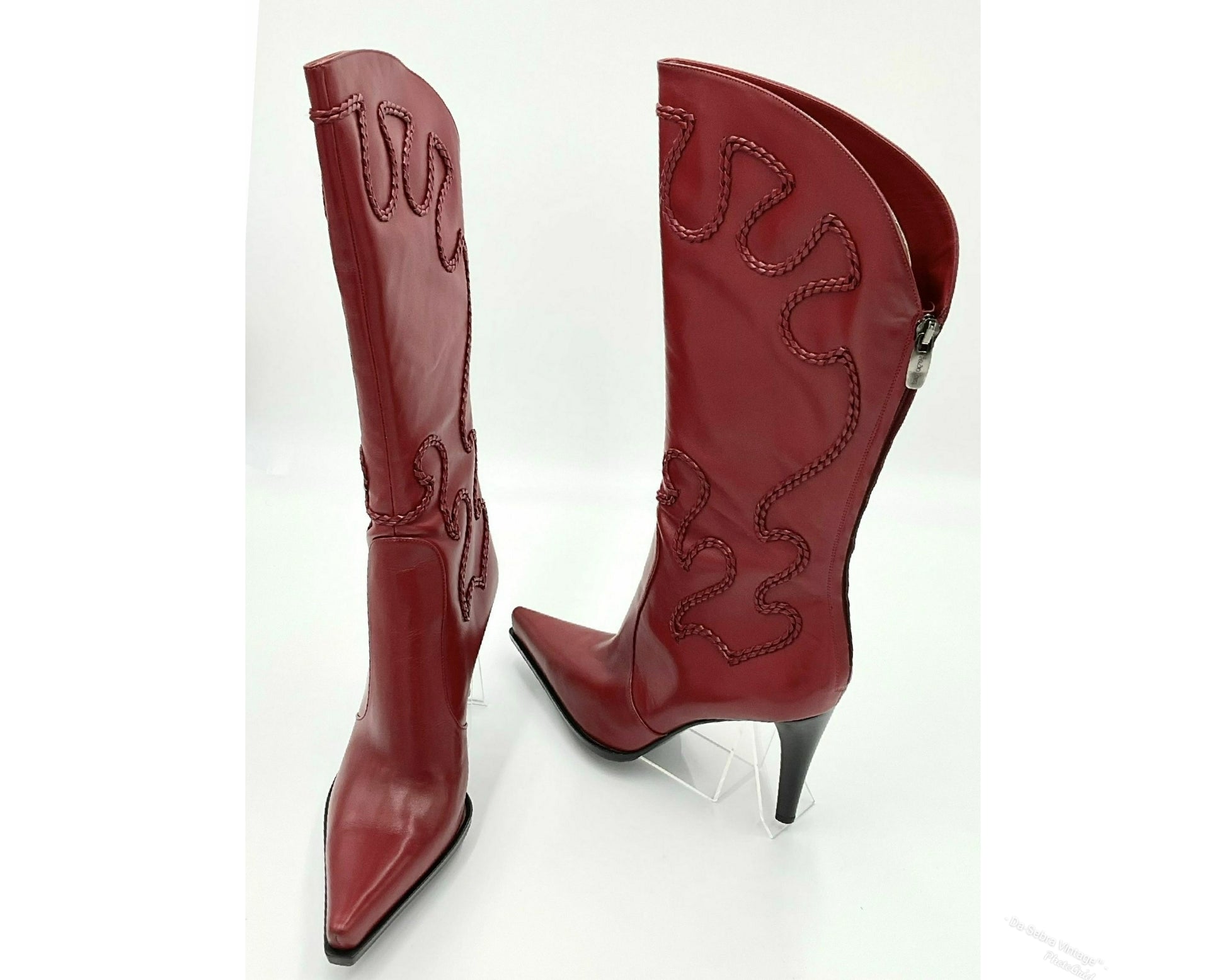 Pair of red cowboy boots with decorative stitching on a white background