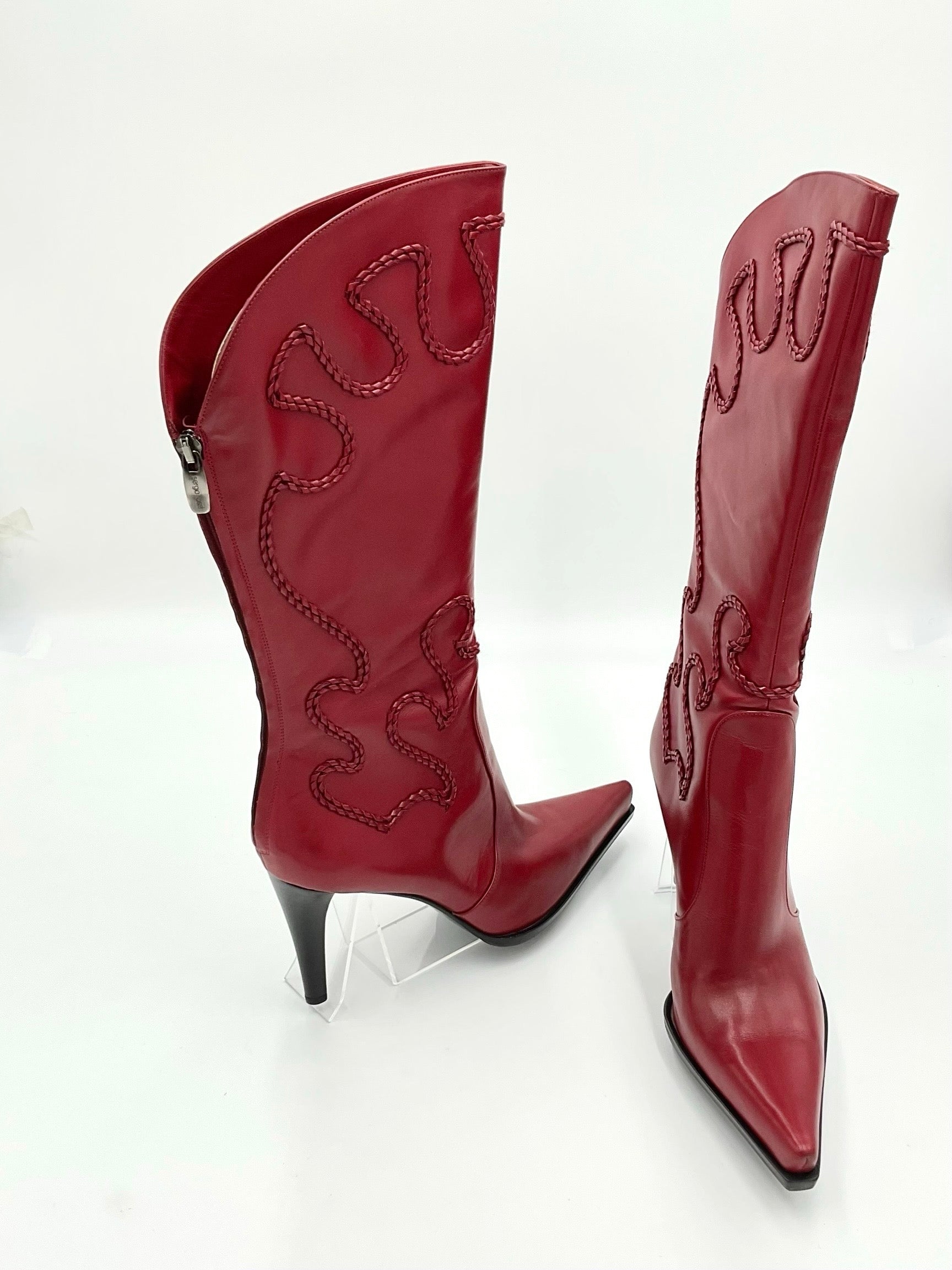 Red high-heeled cowboy boots with decorative stitching on a white background