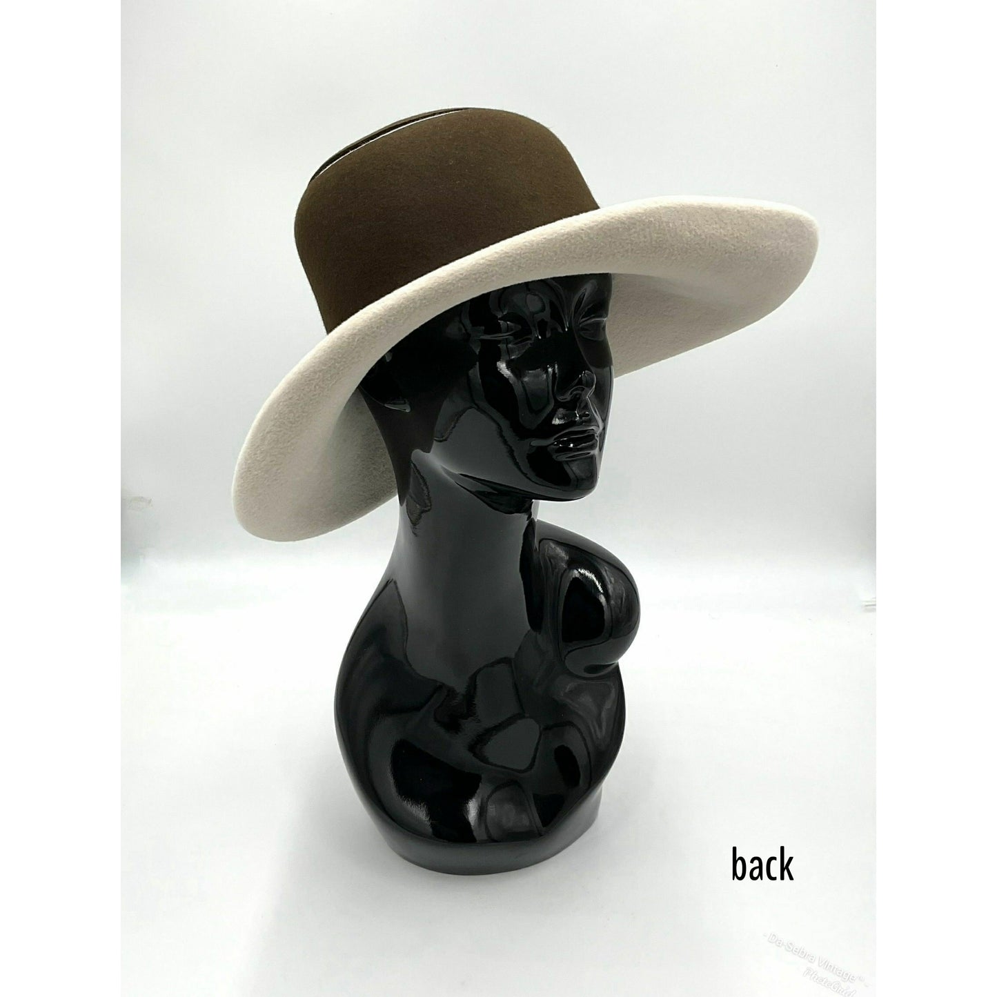 Black mannequin head with a cream and Chocolate brown striped hat on  cream with a Chocolate brown background
