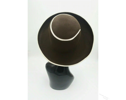 Black mannequin head with a cream and Chocolate brown striped hat on  cream with a Chocolate brown background