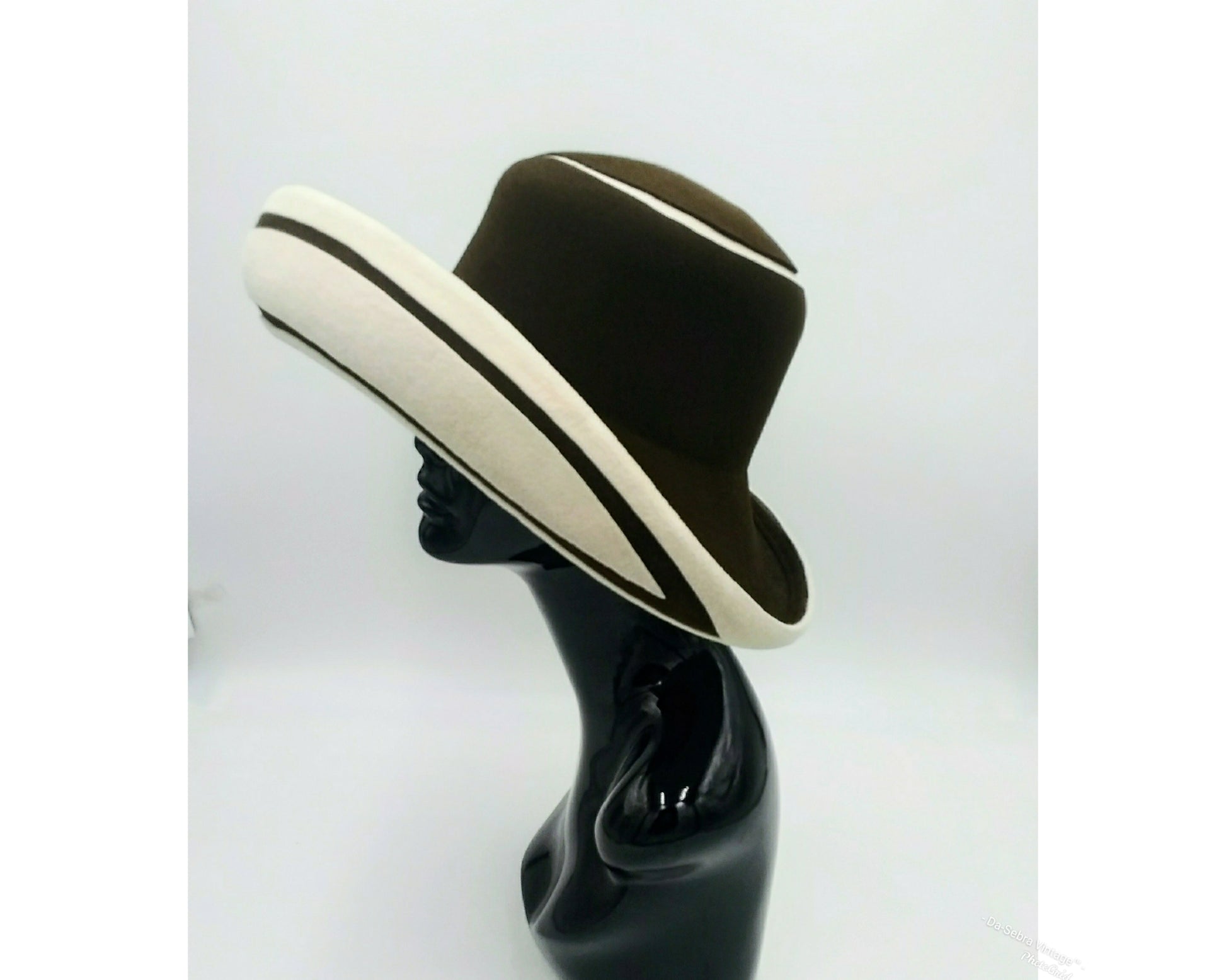Black mannequin head with a cream and Chocolate brown striped hat on  cream with a Chocolate brown background