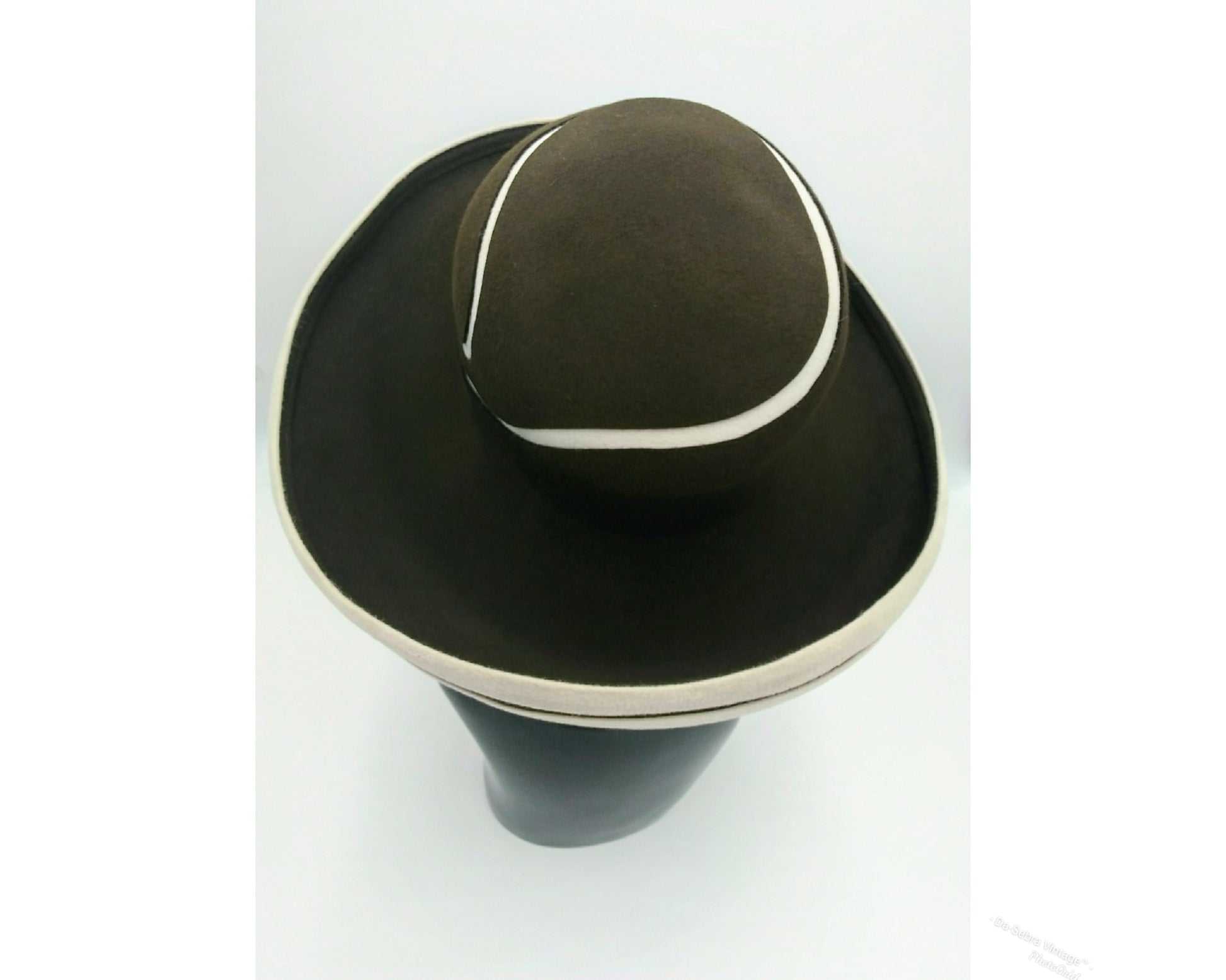 Black mannequin head with a cream and Chocolate brown striped hat on  cream with a Chocolate brown background
