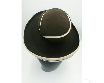 Black mannequin head with a cream and Chocolate brown striped hat on  cream with a Chocolate brown background