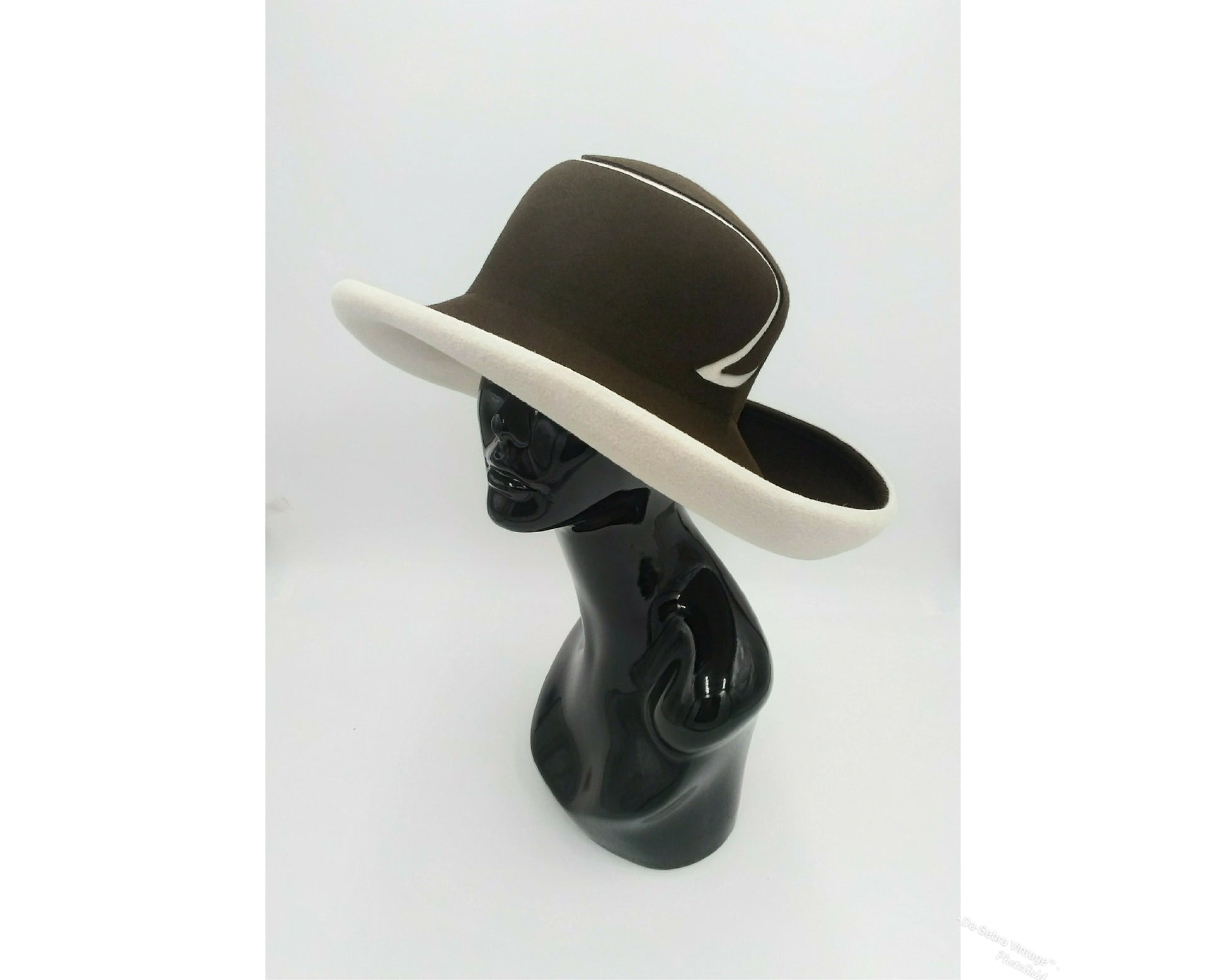Black mannequin head with a cream and Chocolate brown striped hat on  cream with a Chocolate brown background