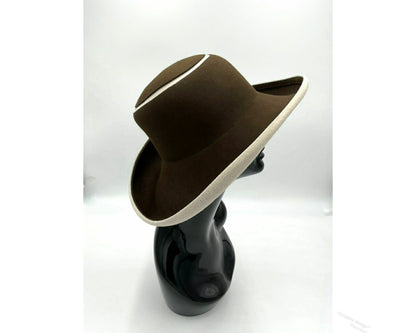 Black mannequin head with a cream and Chocolate brown striped hat on  cream with a Chocolate brown background