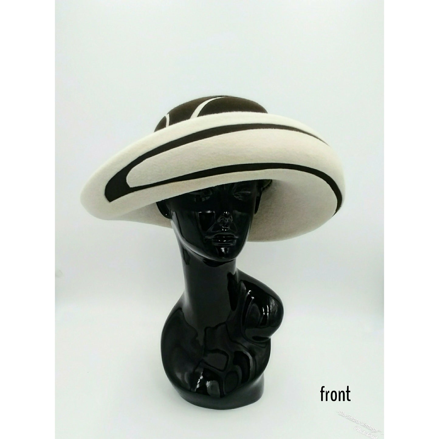 Black mannequin head with a cream and Chocolate brown striped hat on  cream with a Chocolate brown background