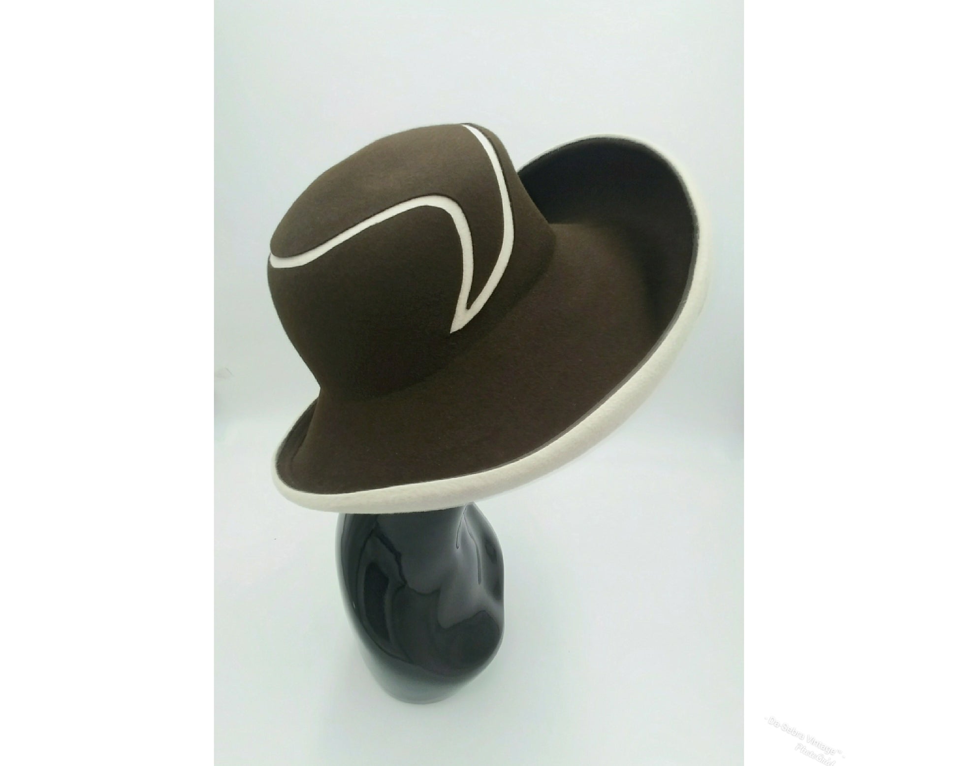 Black mannequin head with a cream and Chocolate brown striped hat on  cream with a Chocolate brown background