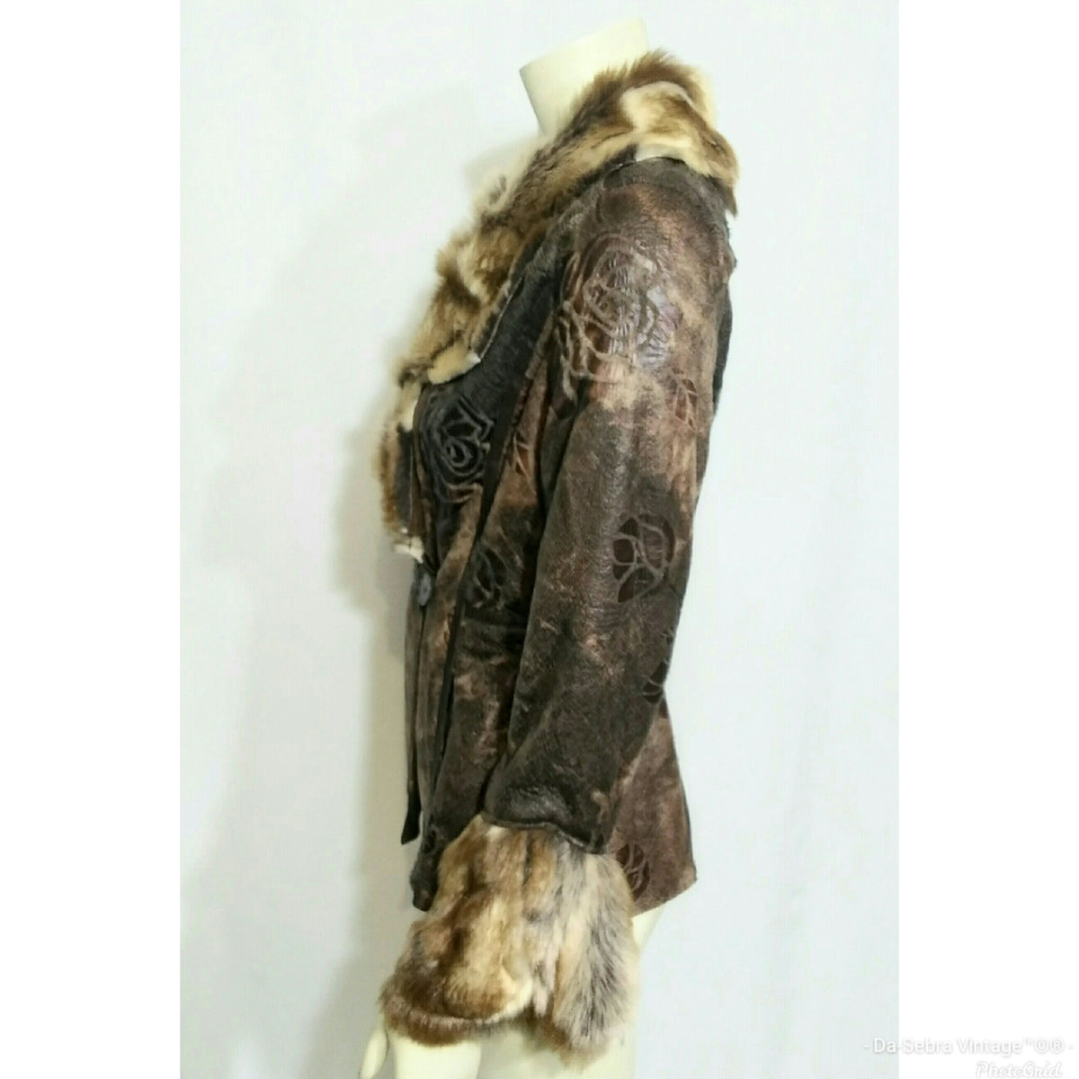 A vintage brown patterned jacket with a brown and beige fur collar and hem, displayed on a cream mannequin torso against a white background.