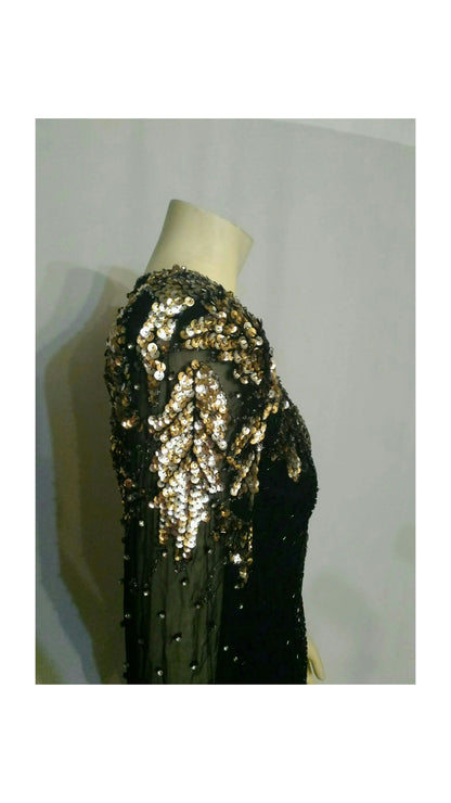 A black sequined dress displayed on a cream mannequin showcasing the sequins on the top of  sleeve.