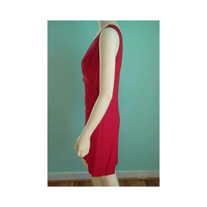 A sleeveless red dress displayed on a mannequin from the side against a teal wall.