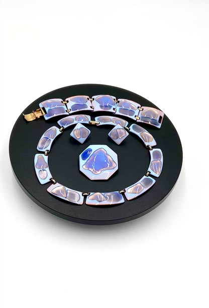 Video of  4 piece including a necklace, bracelet, matching earrings and brooch. The color palette is exceptional: a striking opalescent blue enamel with beautiful hints of lavender and purple tones faceted blue and white stones set in silver-toned metal